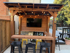 Outdoor wooden bar with TV and seating area
